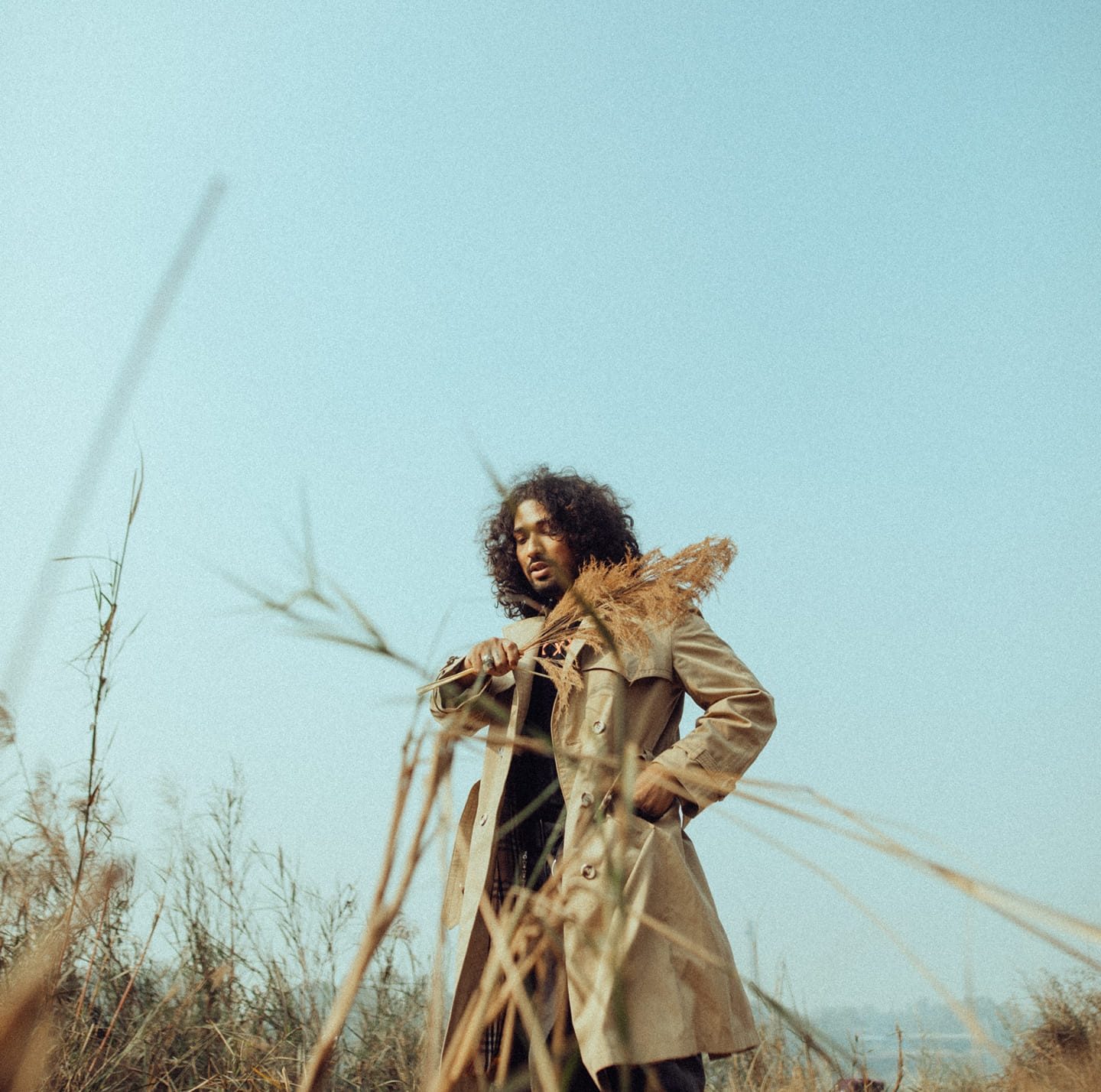 Eklavya standing in tall dry grass under an open sky
